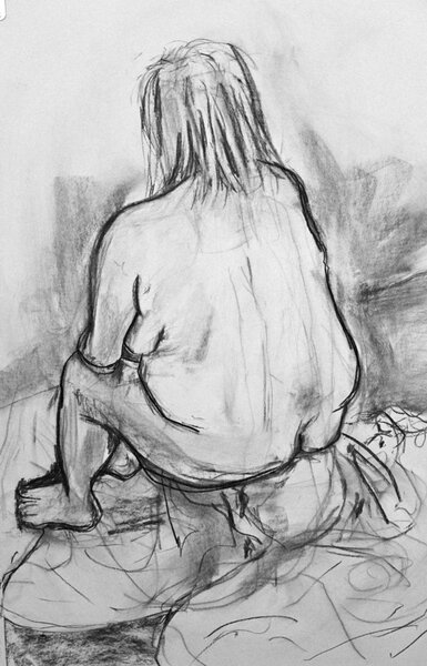 A charcoal life drawing of a sitring figure from behind.